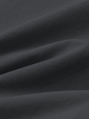 Macro view of the dark grey youth water resistant cotton blend golf pants fabric, showcasing the water repellent surface
