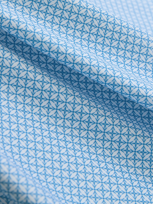 Close-up of light blue geo lightweight stretch upgraded print golf polo shirts, showcasing texture and print details.