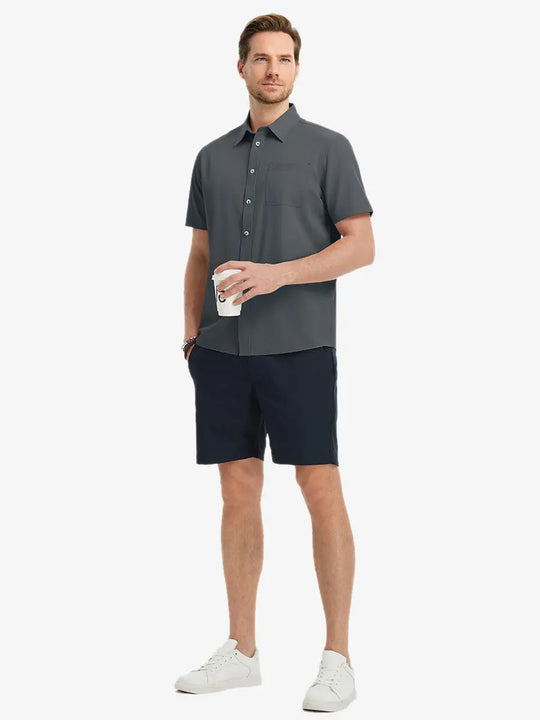 Detail shot with model holding a takeaway drink, featuring the DARK GREY polo’s side vent.